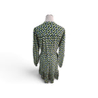 A long-sleeve dress shown from the back on a mannequin, featuring an all-over geometric pattern in green, navy blue, and white.