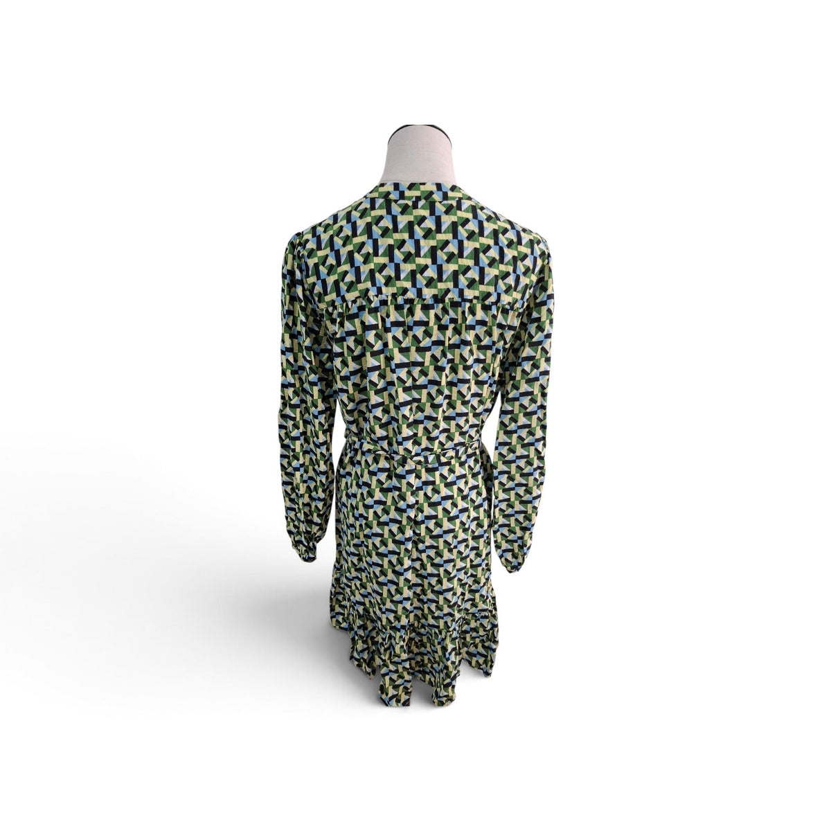 A long-sleeve dress shown from the back on a mannequin, featuring an all-over geometric pattern in green, navy blue, and white.