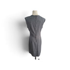 A sleeveless gray and white micro-check patterned dress displayed on a mannequin torso against a white background.