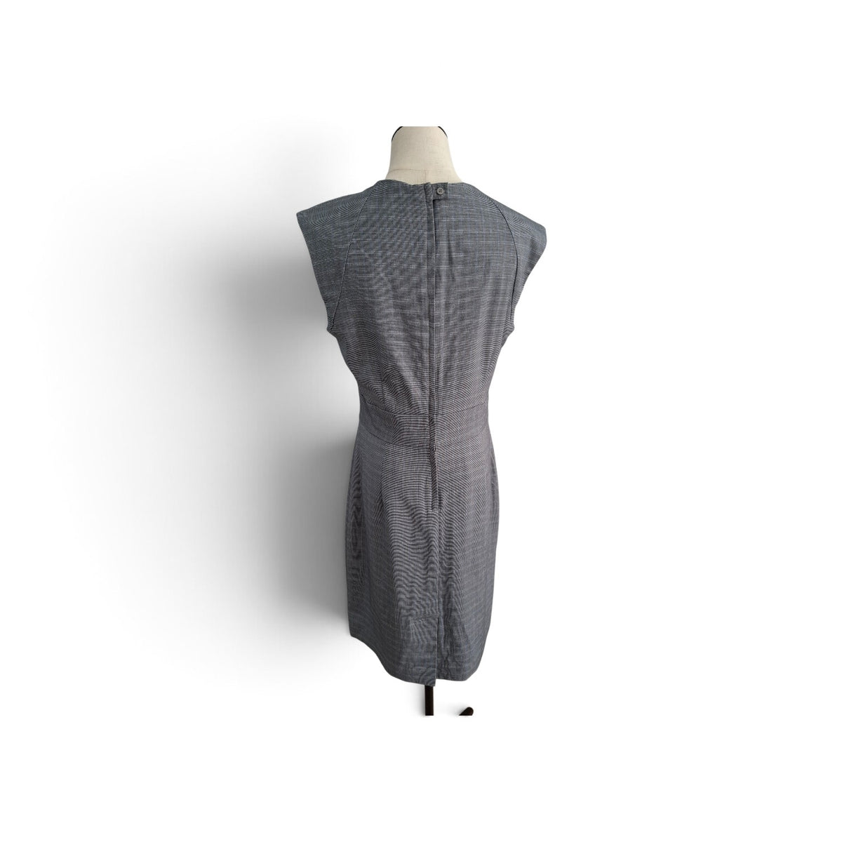 A sleeveless gray and white micro-check patterned dress displayed on a mannequin torso against a white background.