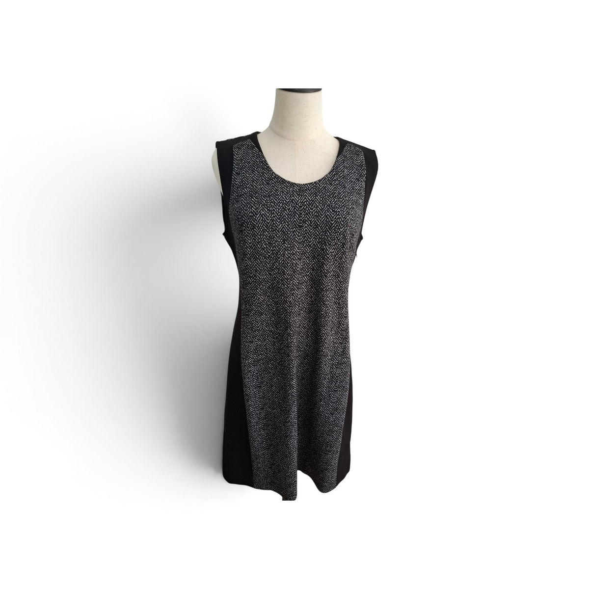 A sleeveless black and gray marled knit dress displayed on a cream mannequin torso against a white background.