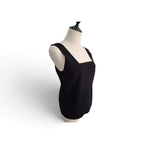 A black sleeveless knit top with a square neckline, displayed on a cream-colored dress form mannequin against a white background.