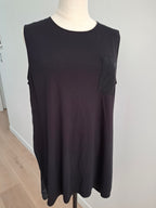 A sleeveless black tunic top with a small chest pocket, displayed on a mannequin torso.
