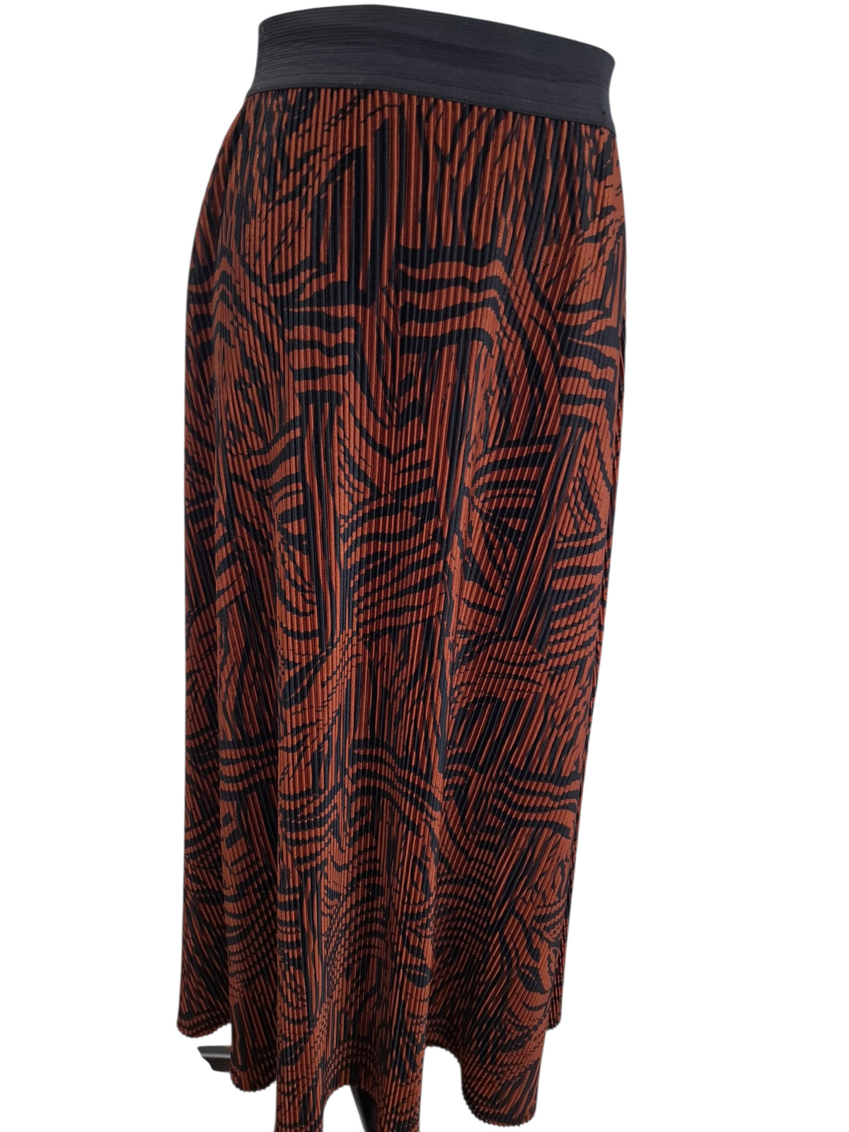 A pleated midi skirt with a rust-orange and black abstract wavy pattern, featuring a solid black waistband.
