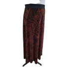 A long pleated skirt with a black and rust-orange abstract pattern, displayed on a white mannequin torso against a white background.