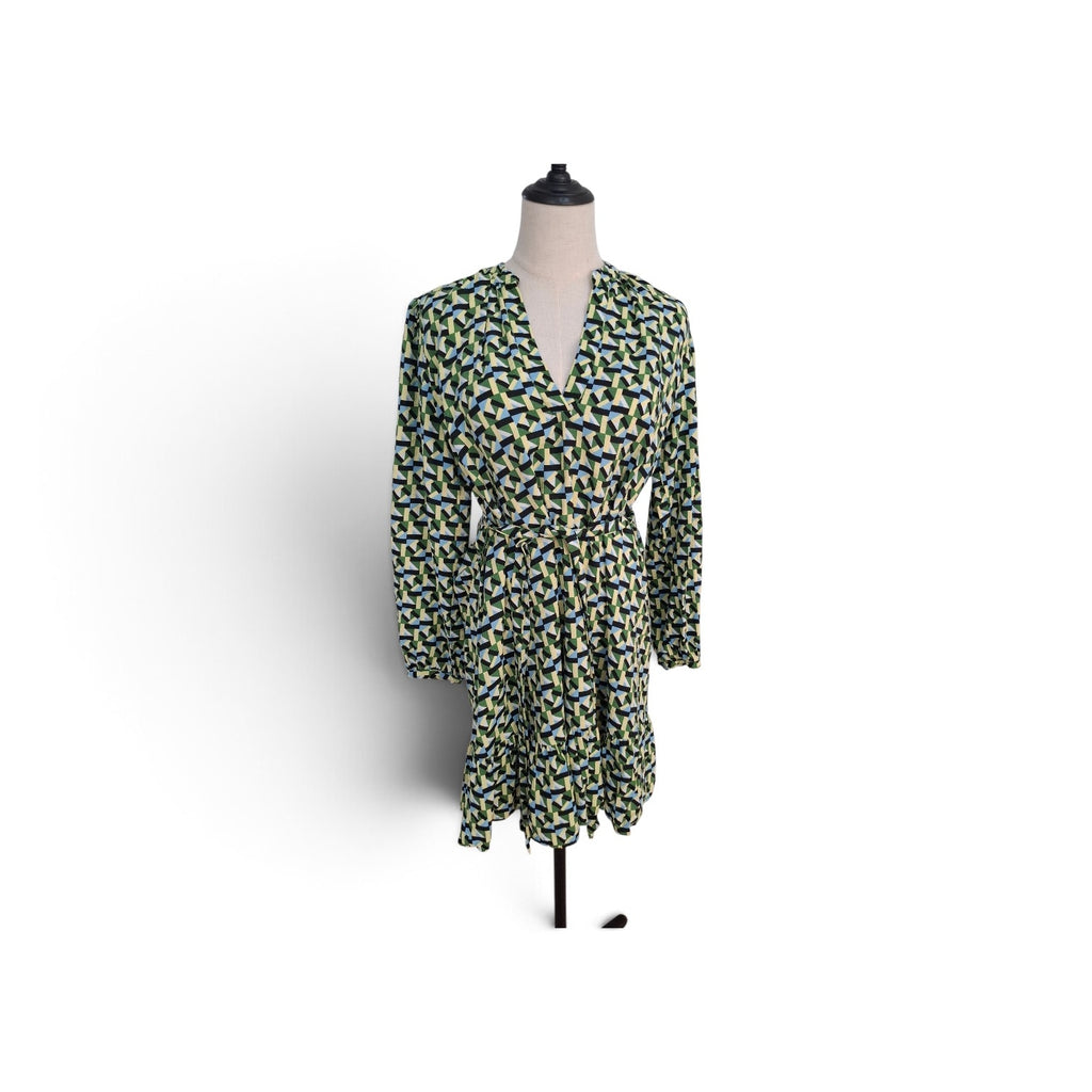 A long-sleeve wrap dress with a green, yellow, and blue geometric pattern, displayed on a mannequin against a white background.