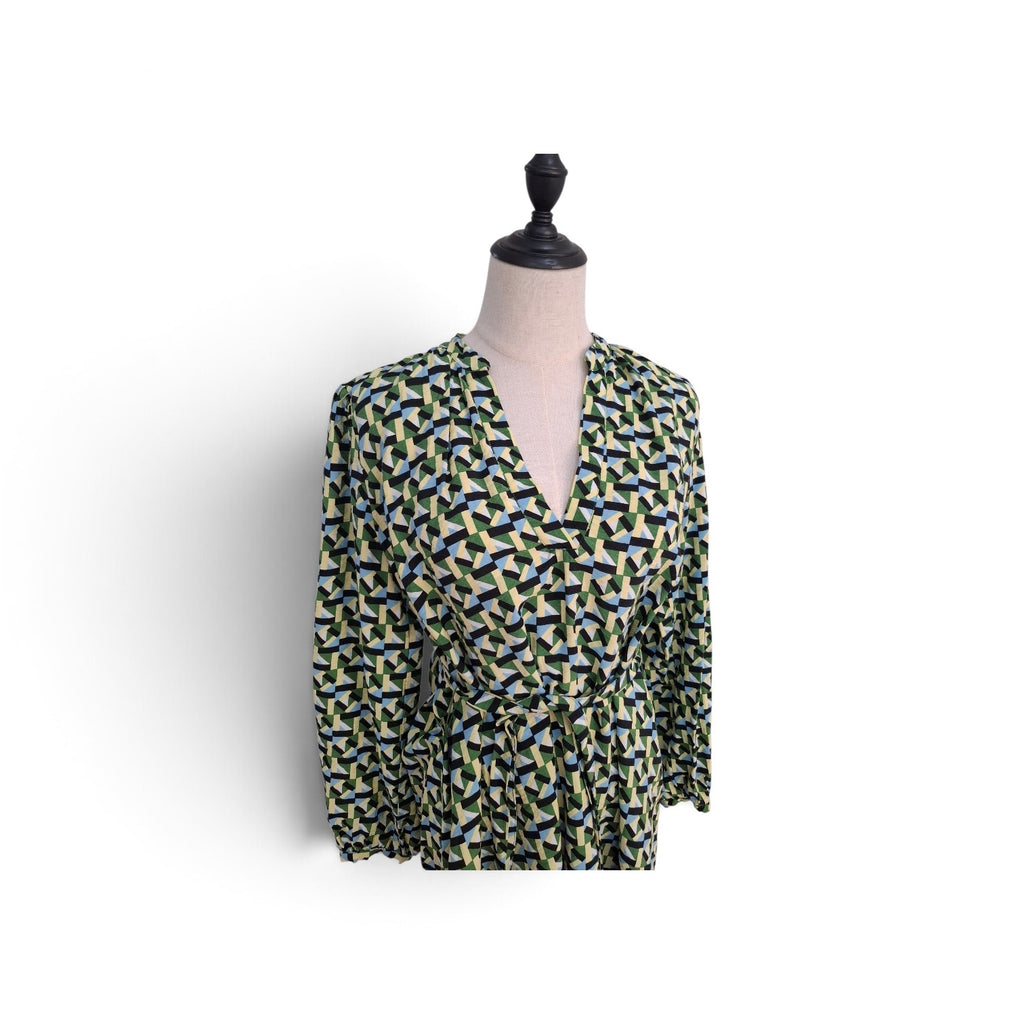 A long-sleeve wrap-style blouse with a geometric pattern in olive green, navy blue, and light blue, displayed on a mannequin torso against a white background.