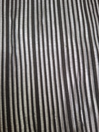 A close-up of a striped fabric with alternating vertical stripes of black, dark gray, and off-white.