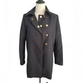 A black double-breasted coat with decorative gold-tone buttons, displayed on a mannequin torso against a plain white background.