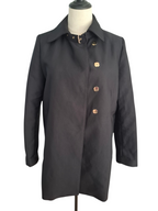 A black trench coat with decorative gold-tone buttons and a collar, displayed on a dress form mannequin against a white background.