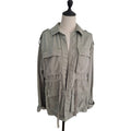 A light olive green military-style utility jacket displayed on a cream dress form mannequin against a plain white background.