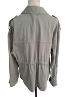A light gray utility jacket with shoulder epaulets and a gathered waist, displayed on a mannequin from the back against a white background.