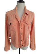 A peach-colored denim jacket displayed on a cream-colored dress form mannequin against a plain white background.