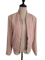 A light pink bomber jacket displayed on a beige dress form mannequin against a plain white background.