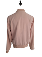 A light pink long-sleeve bomber jacket shown from the back, displayed on a black mannequin torso against a plain white background.