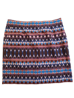 A short A-line skirt featuring a horizontal geometric pattern with blue, brown, pink, and white diamond and oval motifs.