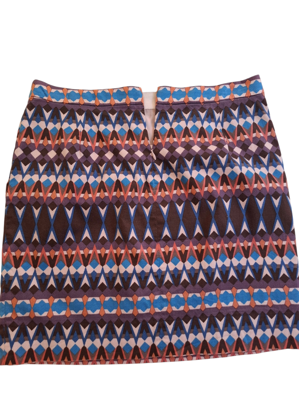 A short A-line skirt with a vibrant geometric ikat pattern featuring blue, purple, brown, and orange on a white background.
