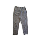 A pair of gray textured trousers laid flat on a white background.