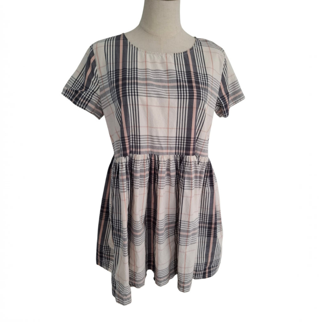 A short-sleeve plaid dress displayed on a mannequin torso against a plain white background. The dress features a cream base with intersecting dark gray, black, and thin pink stripes in a plaid pattern.