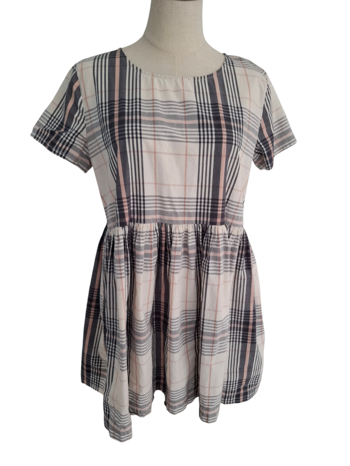 A short-sleeve plaid dress displayed on a mannequin torso against a plain white background. The dress features a beige base with intersecting black, gray, and muted pink plaid lines.