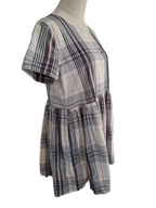 A short-sleeve plaid dress displayed on a mannequin torso against a plain white background. The dress features a beige base with intersecting navy and pink plaid lines.
