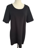 A black short-sleeve tunic top with textured, raised leaf-like patterns on the sleeves, displayed on a cream-colored dress form mannequin against a white background.