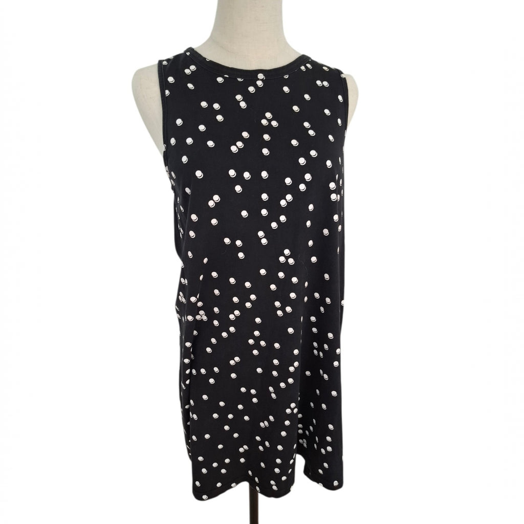A sleeveless black shift dress with an all-over white polka dot pattern, displayed on a beige mannequin torso against a plain white background.