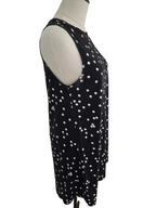 A sleeveless black tunic top with a white polka dot pattern, displayed on a cream-colored dress form mannequin against a plain white background.