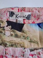 Close-up of a Ketz-ke brand garment label sewn onto a floral printed fabric, showing the size 12 USA-M measurement.
