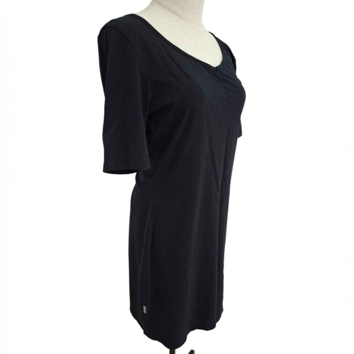 A black short-sleeve tunic top displayed on a cream mannequin torso against a plain white background.