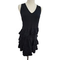 A black sleeveless V-neck dress displayed on a mannequin torso against a plain white background. The dress features a tiered ruffle hem.