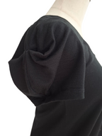 Close-up side view of a black short-sleeve top on a mannequin torso, showing a gathered puff sleeve detail against a plain white background.
