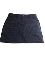 A dark navy blue mini skirt with a button closure and two front flap pockets, laid flat against a white background.