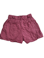 A pair of dusty rose or mauve-colored linen shorts with a gathered elastic waistband and two back welt pockets, shown flat against a white background.
