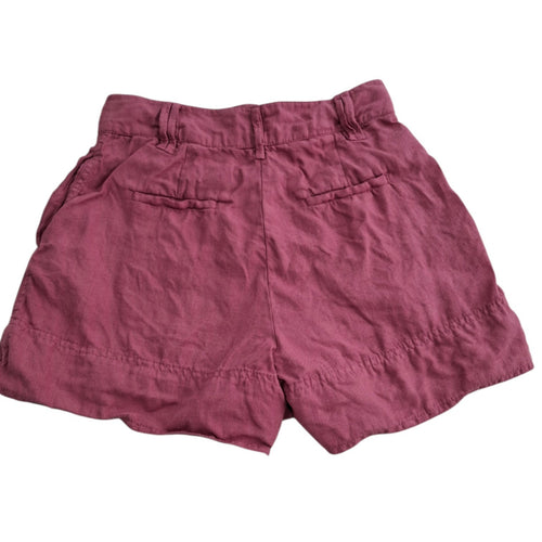 A pair of dusty rose or mauve-colored linen shorts with a relaxed fit, featuring two welt back pockets and a gathered waistband, shown against a plain white background.