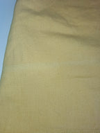 A close-up of a light tan or beige textured fabric, showing a fine diagonal twill weave pattern.