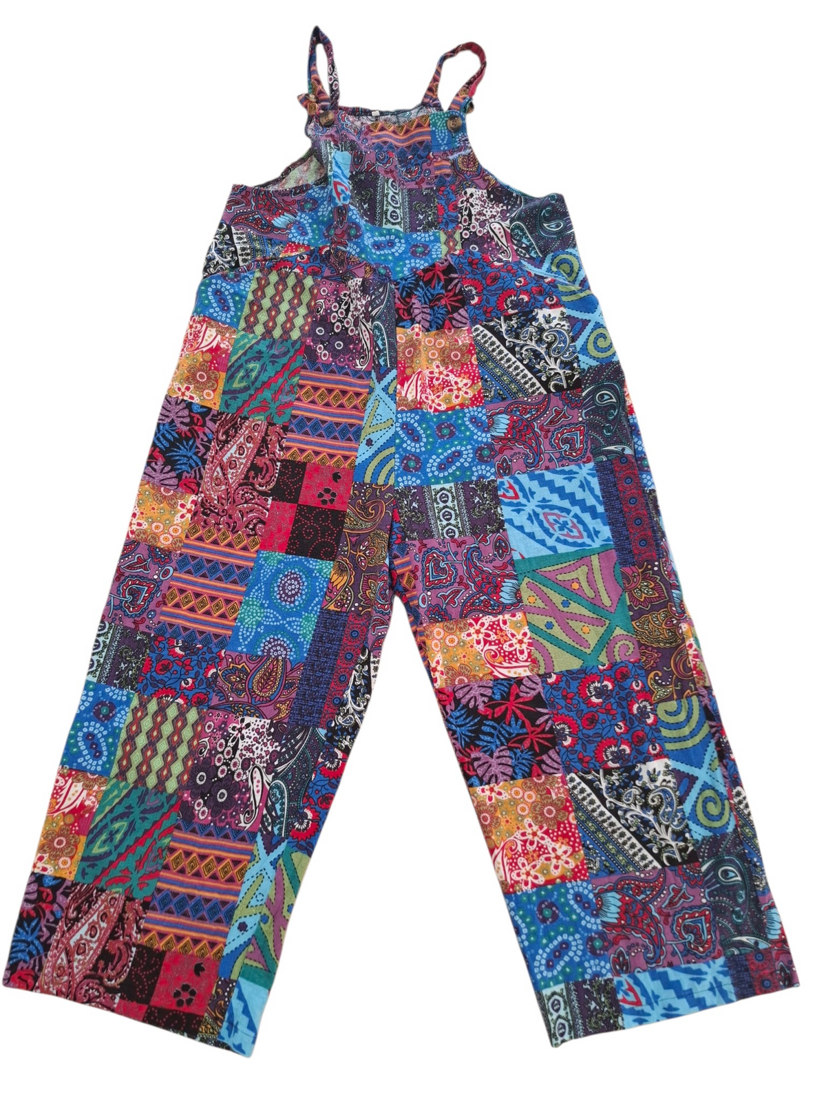 A pair of patchwork patchwork-style pants with thin shoulder straps, featuring a vibrant multicolor pattern of various paisley, floral, and geometric fabric panels on a white background.