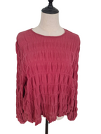 A textured, long-sleeve top in a dusty rose or muted magenta color, displayed on a mannequin torso against a plain white background.