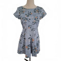A short-sleeve fit-and-flare dress with a floral print in dusty blue, green, and orange, displayed on a mannequin against a white background.
