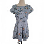 A short-sleeve fit-and-flare dress with a floral print in dusty blue, green, and orange, displayed on a mannequin against a white background.