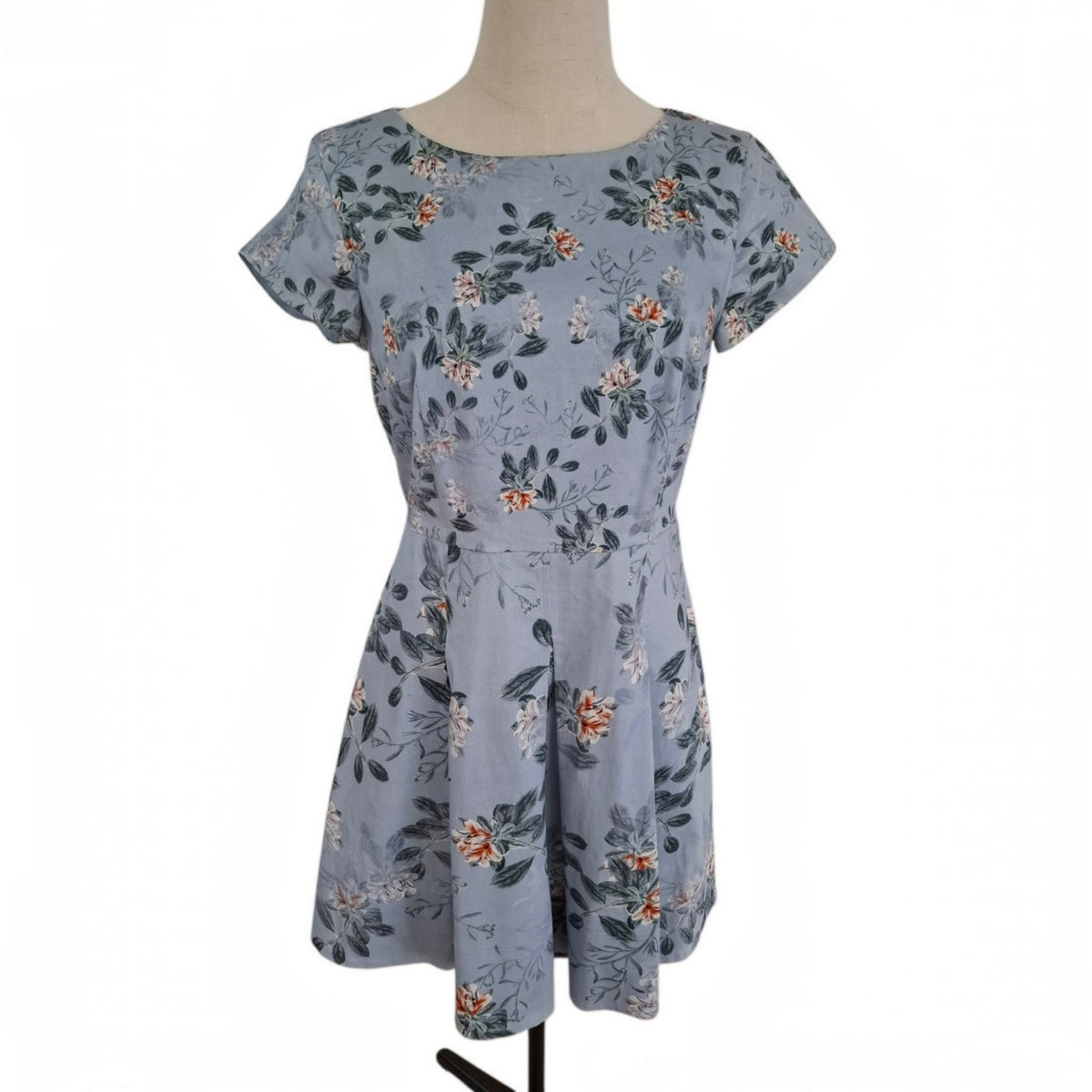 A short-sleeve fit-and-flare dress with a floral print in dusty blue, green, and orange, displayed on a mannequin against a white background.