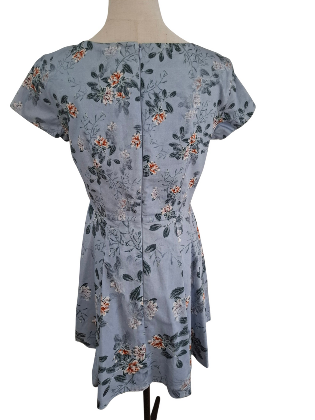 A short-sleeve peplum-style dress with a floral print, displayed on a mannequin torso against a plain white background.