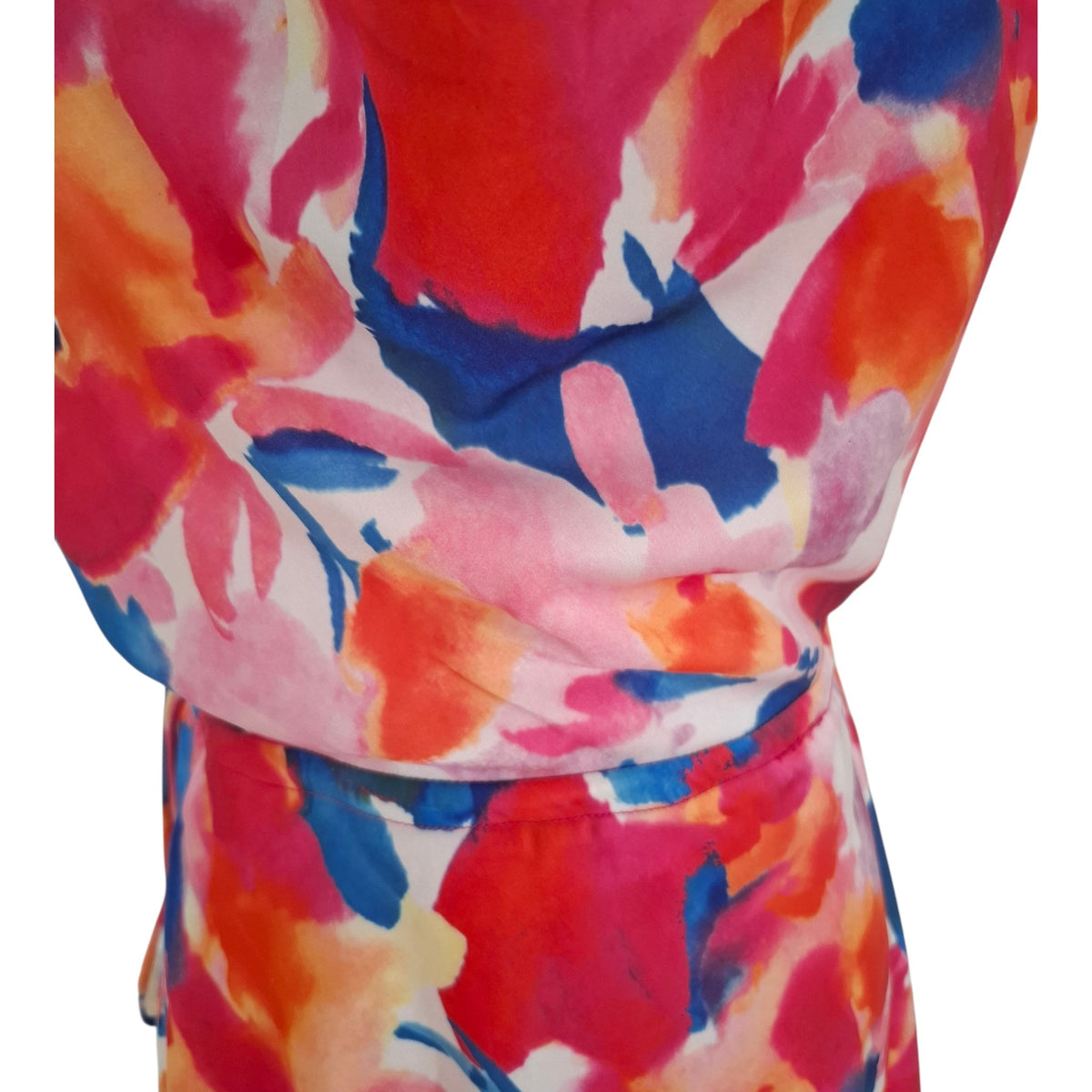 A close-up of a wrap-style dress or skirt with a bold abstract floral print in red, pink, orange, blue, and white, shown against a plain white background.