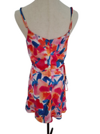 A sleeveless floral print mini dress with thin shoulder straps and a side tie, displayed on a beige fabric mannequin torso against a white background.