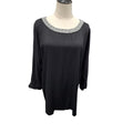 A black long-sleeve tunic top with a textured silver-gray beaded neckline, displayed on a mannequin torso against a white background.