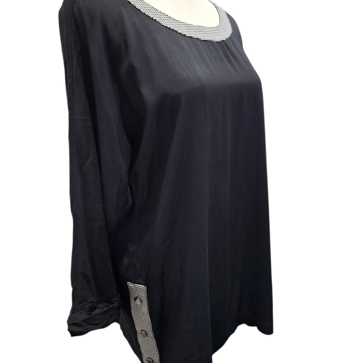 A black long-sleeve tunic top with a textured silver-gray beaded neckline and a matching beaded side detail near the hem, displayed on a mannequin against a white background.