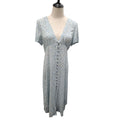 A light blue short-sleeve midi dress with a small multicolor floral print, displayed on a cream dress form mannequin against a white background.