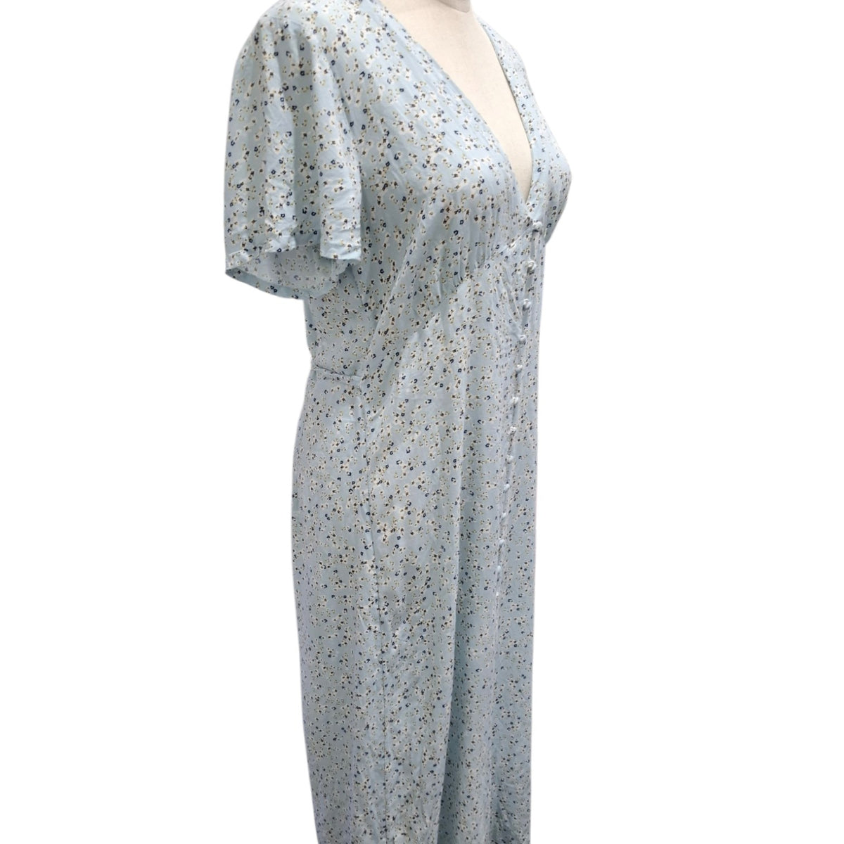 A light blue short-sleeve maxi dress with a small multicolor floral print, displayed on a mannequin against a white background.