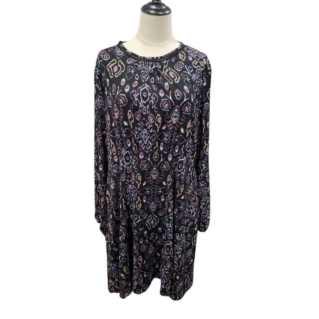 A long-sleeve tunic dress with an intricate multicolor paisley and floral pattern on a black base, displayed on a mannequin torso against a white background.