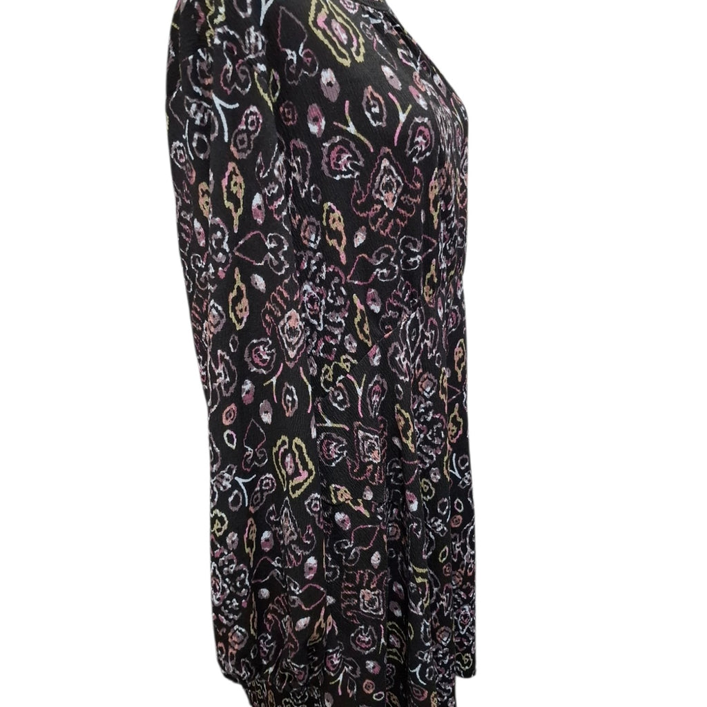 A black long-sleeve top with an all-over abstract floral and paisley print in pink, purple, white, and yellow, shown on a plain white background.